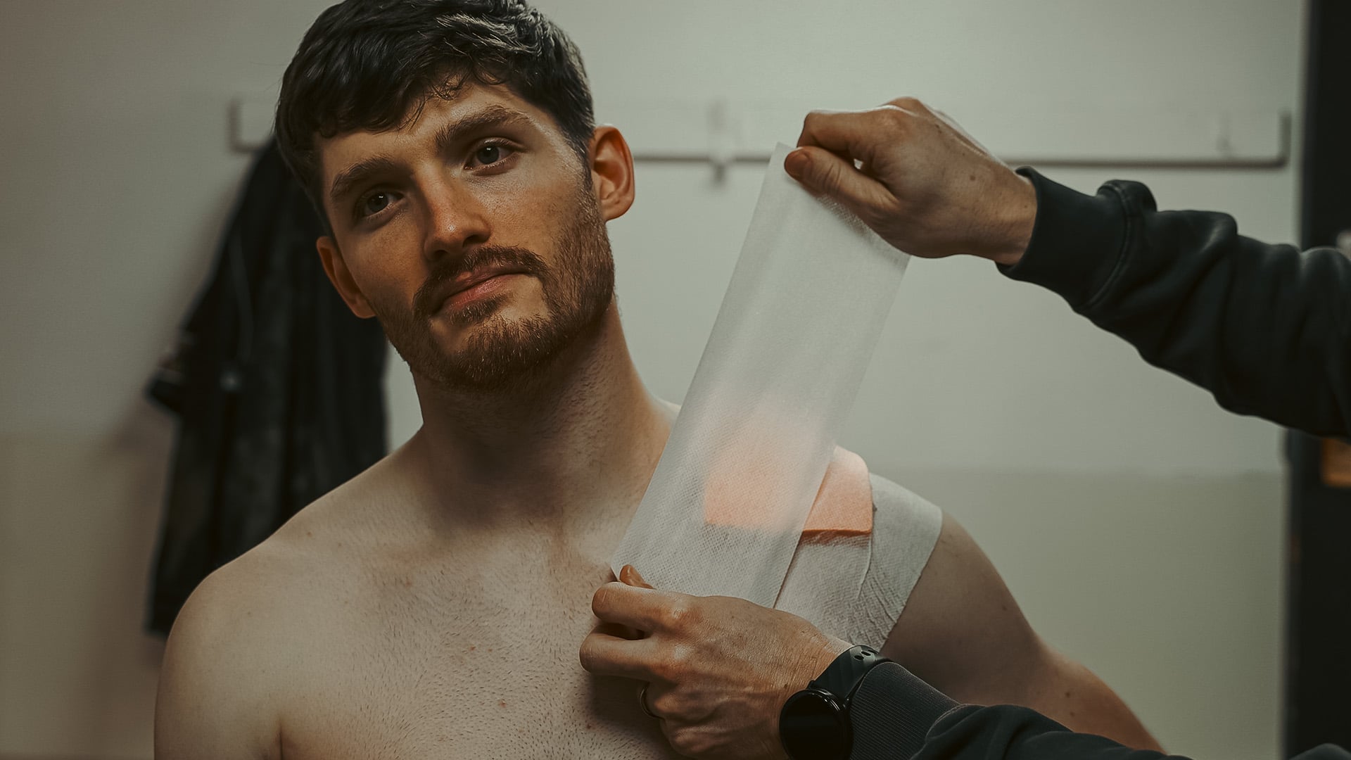 Man having a Dermal Pad affixed to his shoulder with fixation tape
