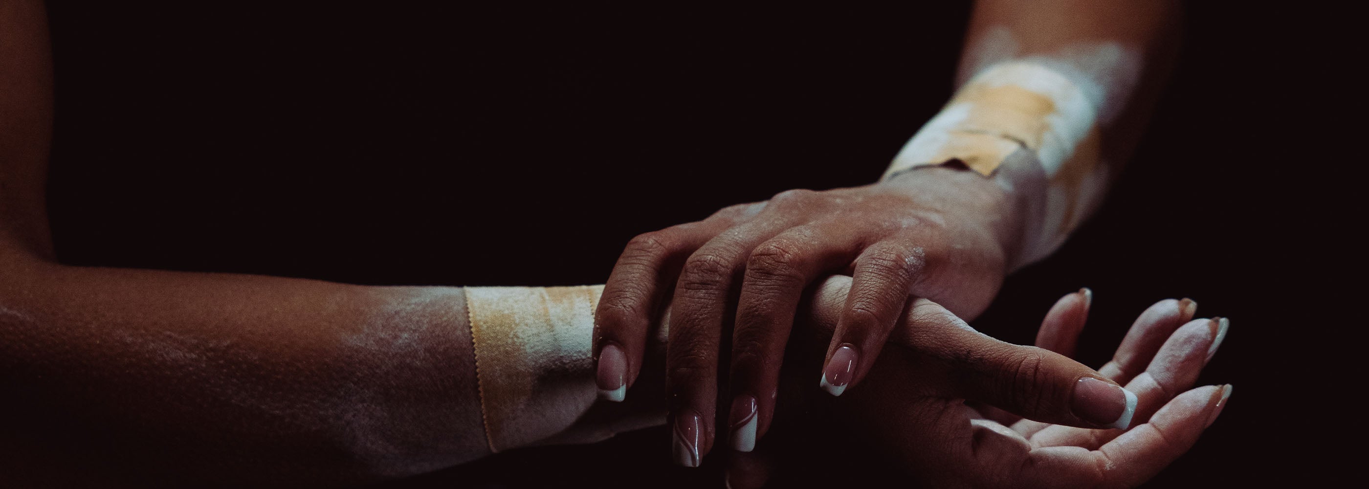 Athlete applying chalk to hands with zinc oxide tan tape on both wrists