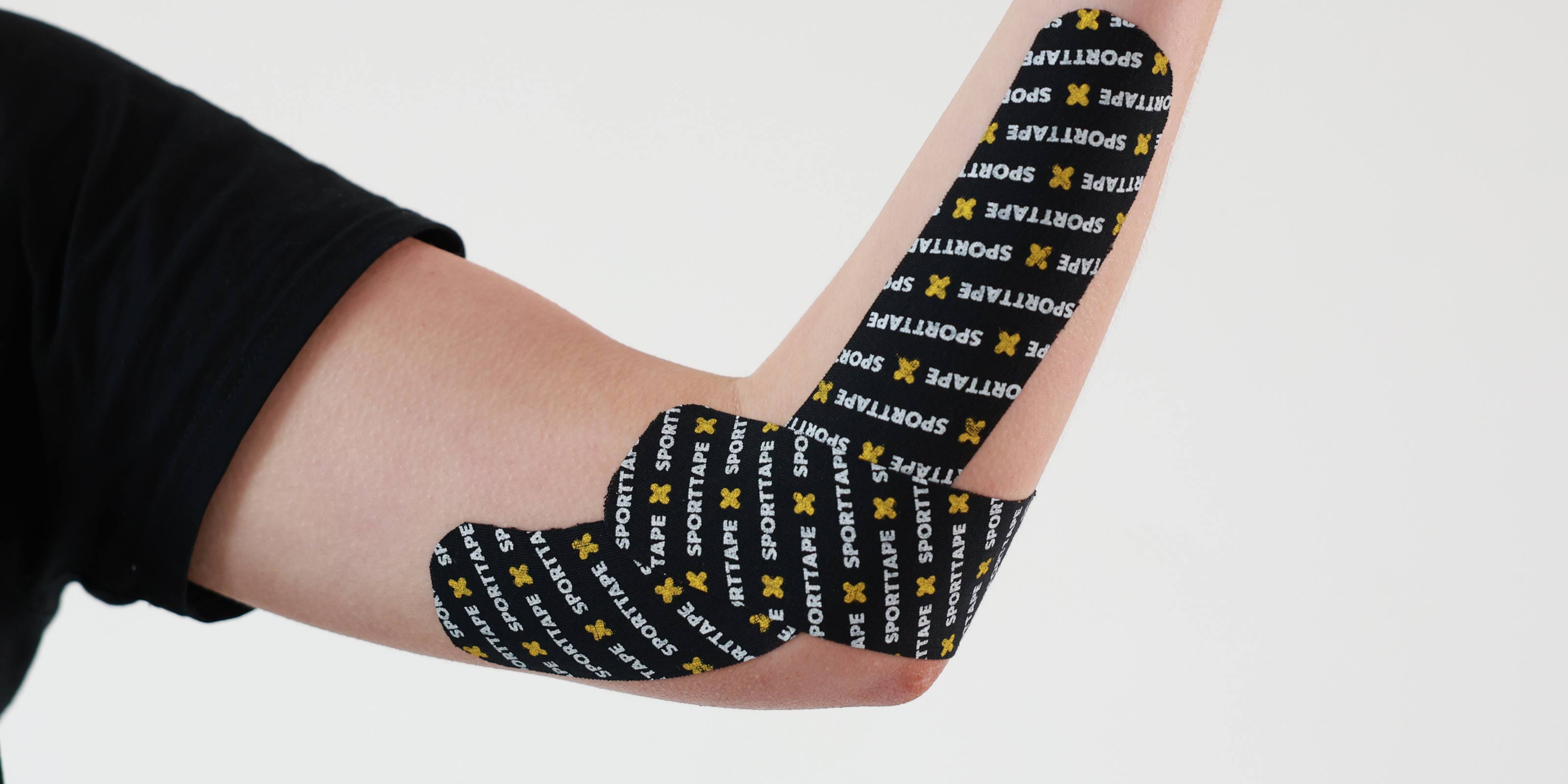 Person wearing SPORTTAPE branded kinesiology tape on the elbow