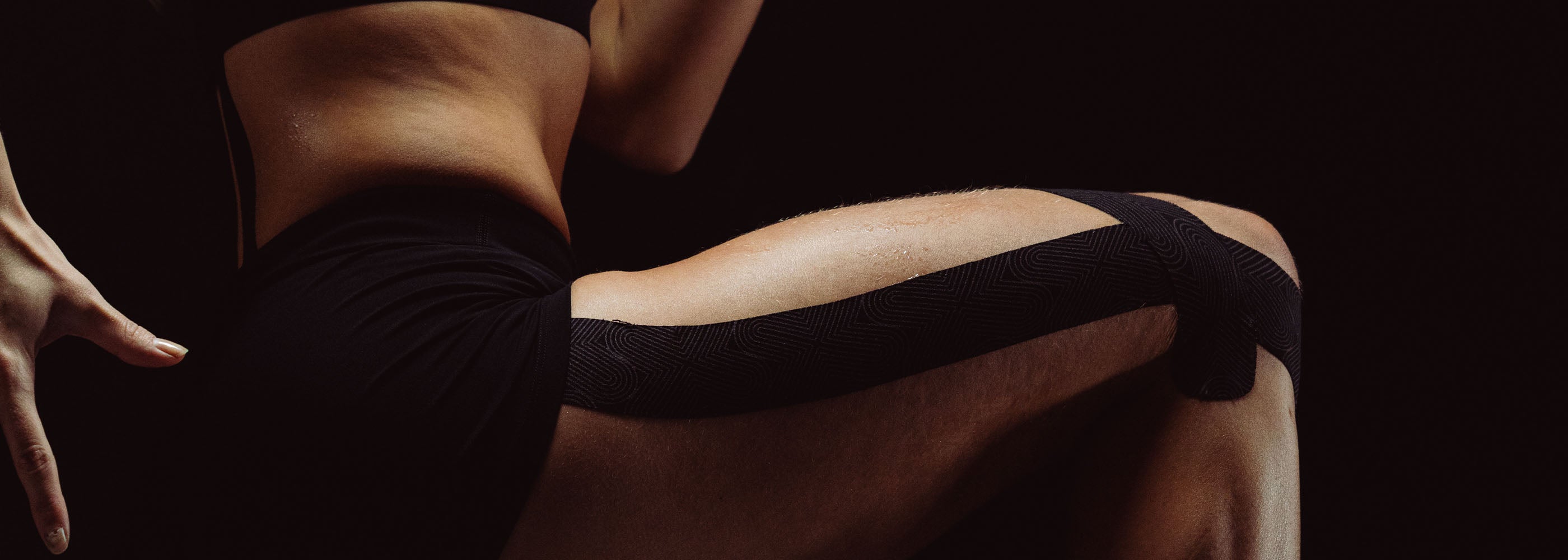 Platinum Kinesiology on a person's quad against a dark background