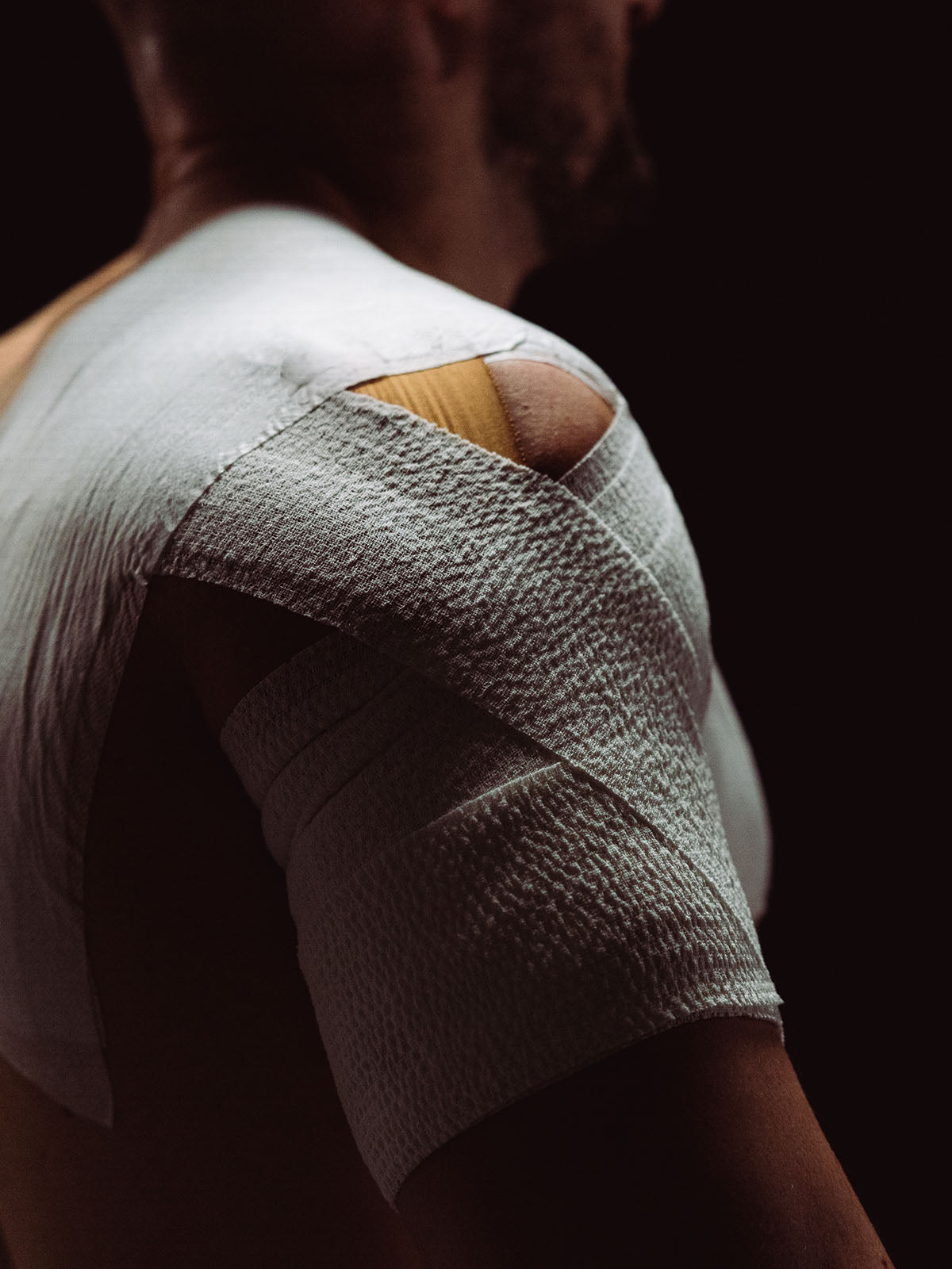 Person with a bandaged arm on a dark background