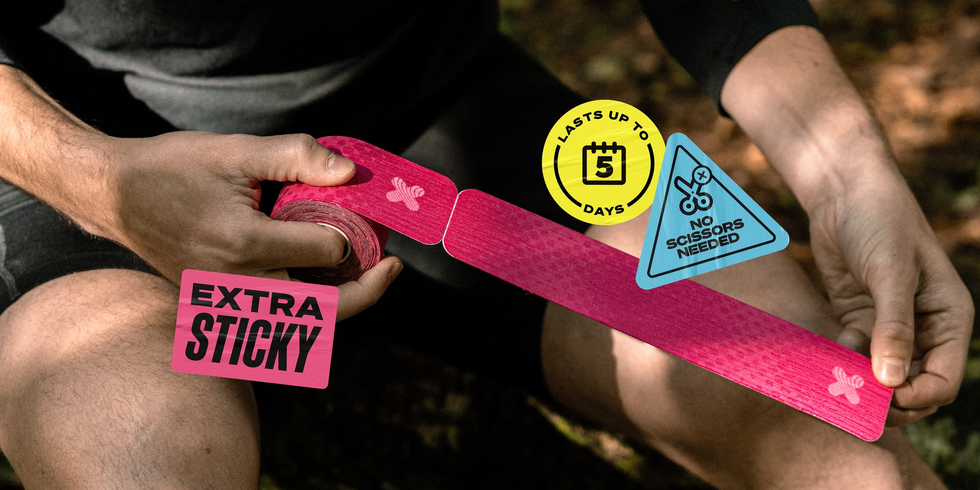 A person outdoors holds a roll of bright pink kinesiology tape, unrolling a long pre-cut strip. Three product feature stickers are shown: a yellow circle reading 'LASTS UP TO 5 DAYS' and a blue triangle reading 'NO SCISSORS NEEDED,' plus a pink rectangle reading 'EXTRA STICKY