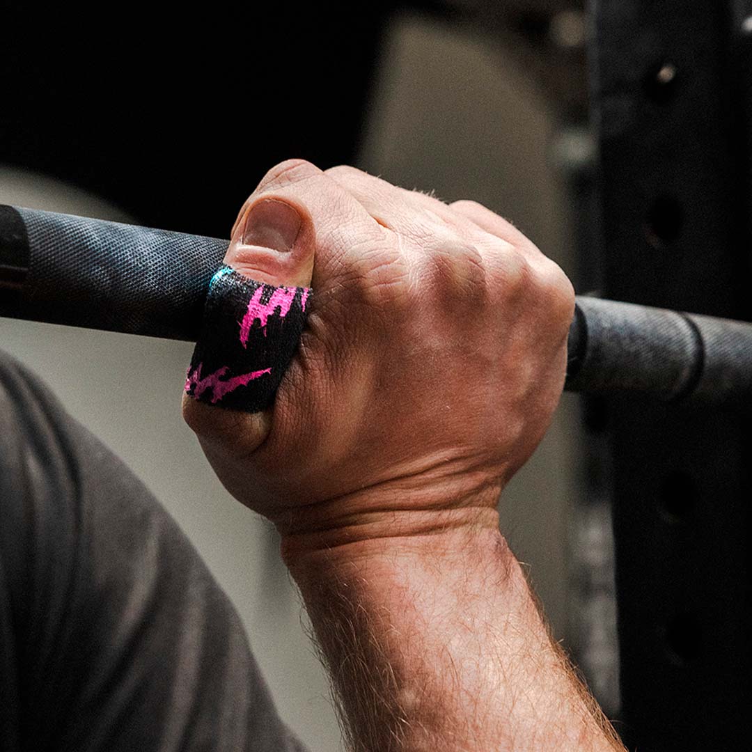 Gripping a barbell wearing Punk Black Thumb Tape