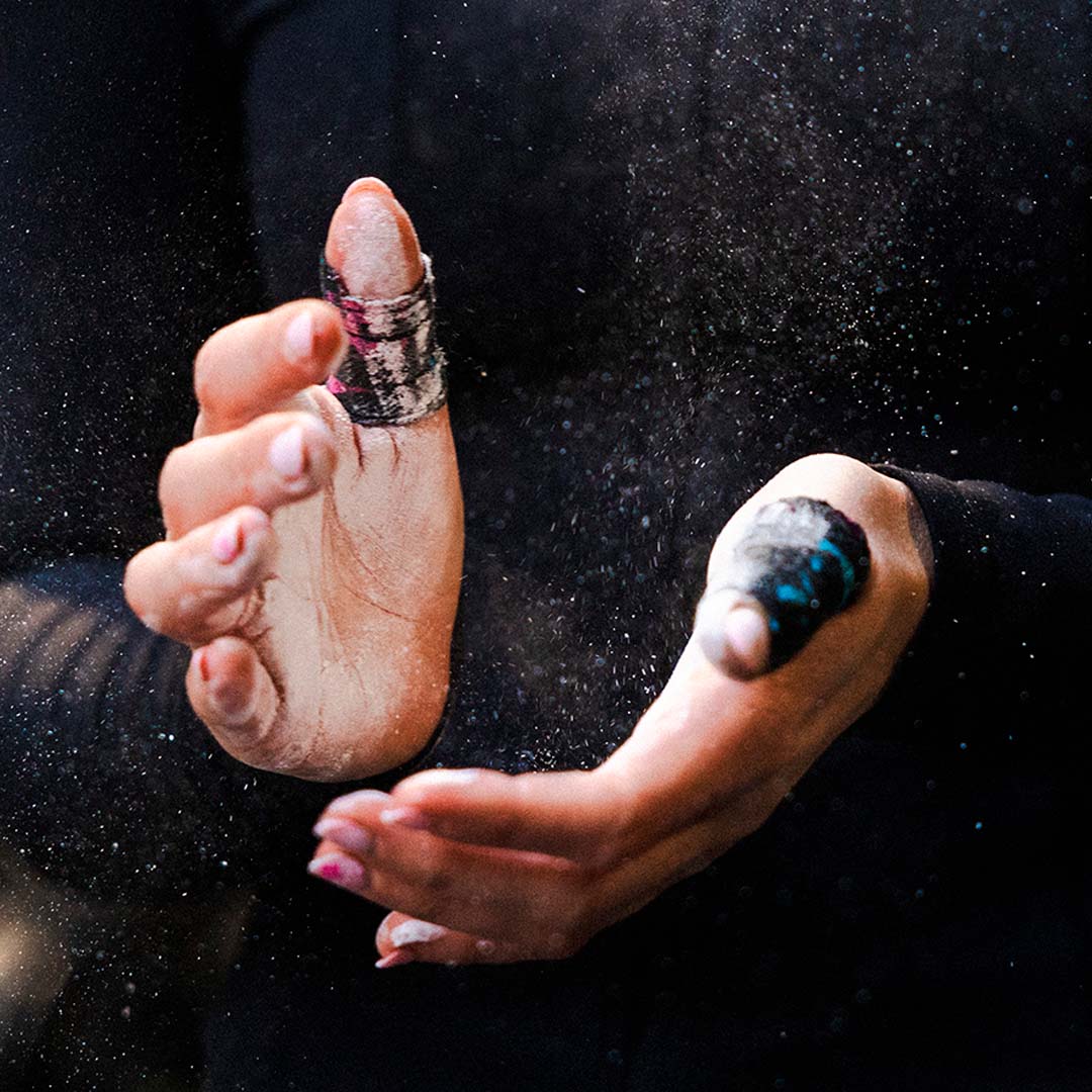Clapping chalking off of hands wearing Punk Black Thumb Tape on both thumbs