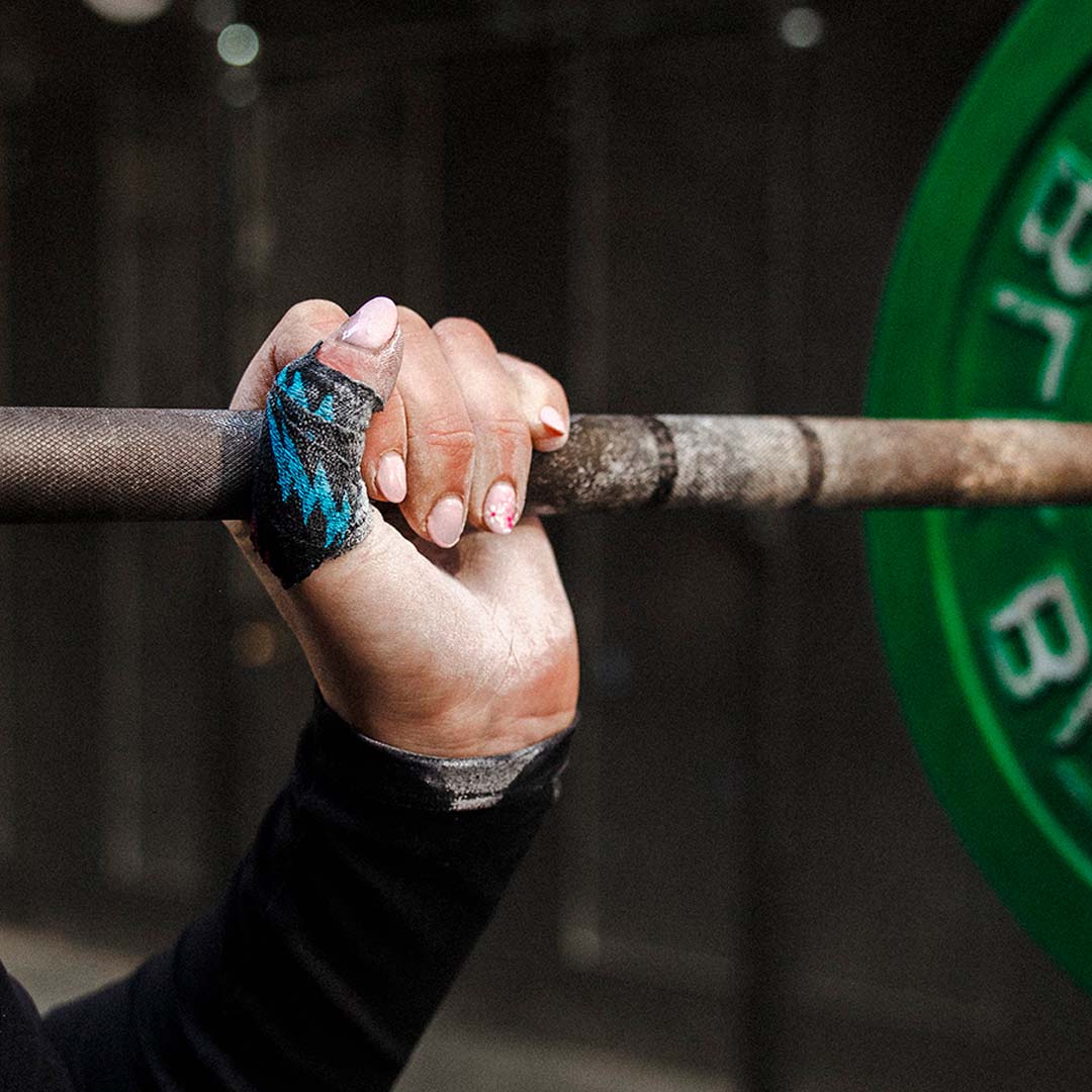 Lifting a barbell wearing Punk Black Thumb Tape