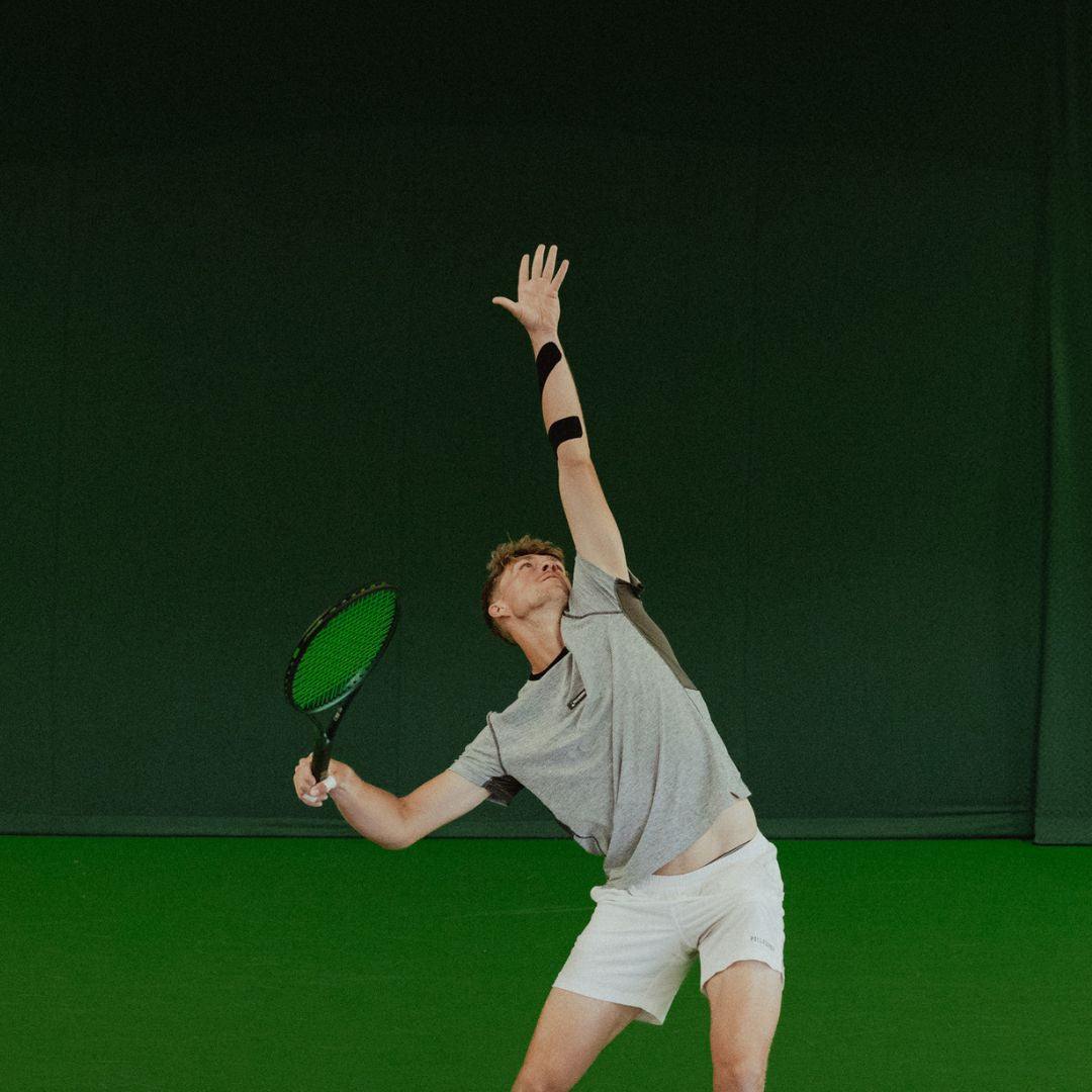 Image shows a tennis elbow application in action. Kinesiology Tape has been used to strap up a tennis player and the image has been used for a blog.